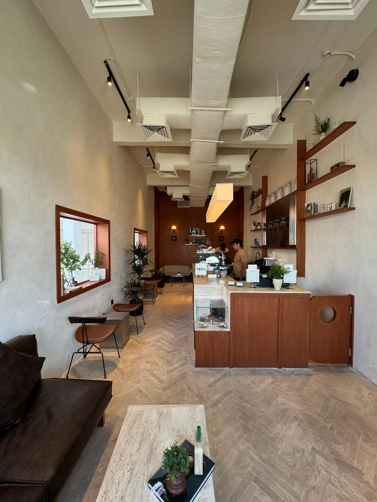 Interior of Très Café Abu Halifa with wooden decor and soft lighting